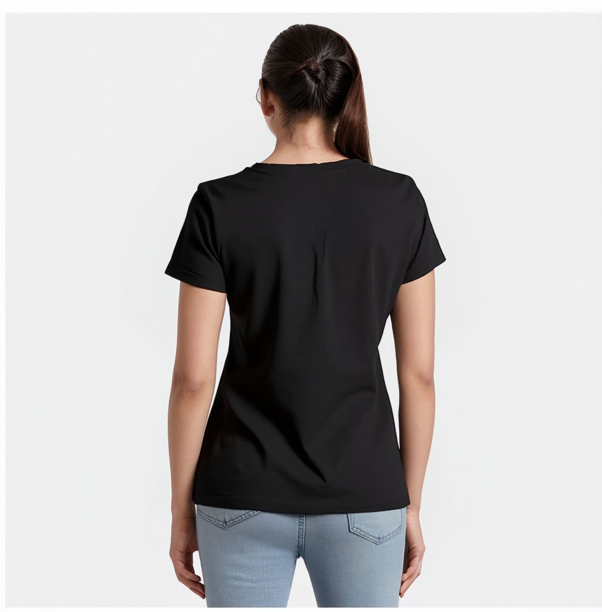 Back view of a woman wearing a plain black t-shirt with short sleeves and light blue jeans. Her hair is tied back in a ponytail, and she is standing against a plain white background.

