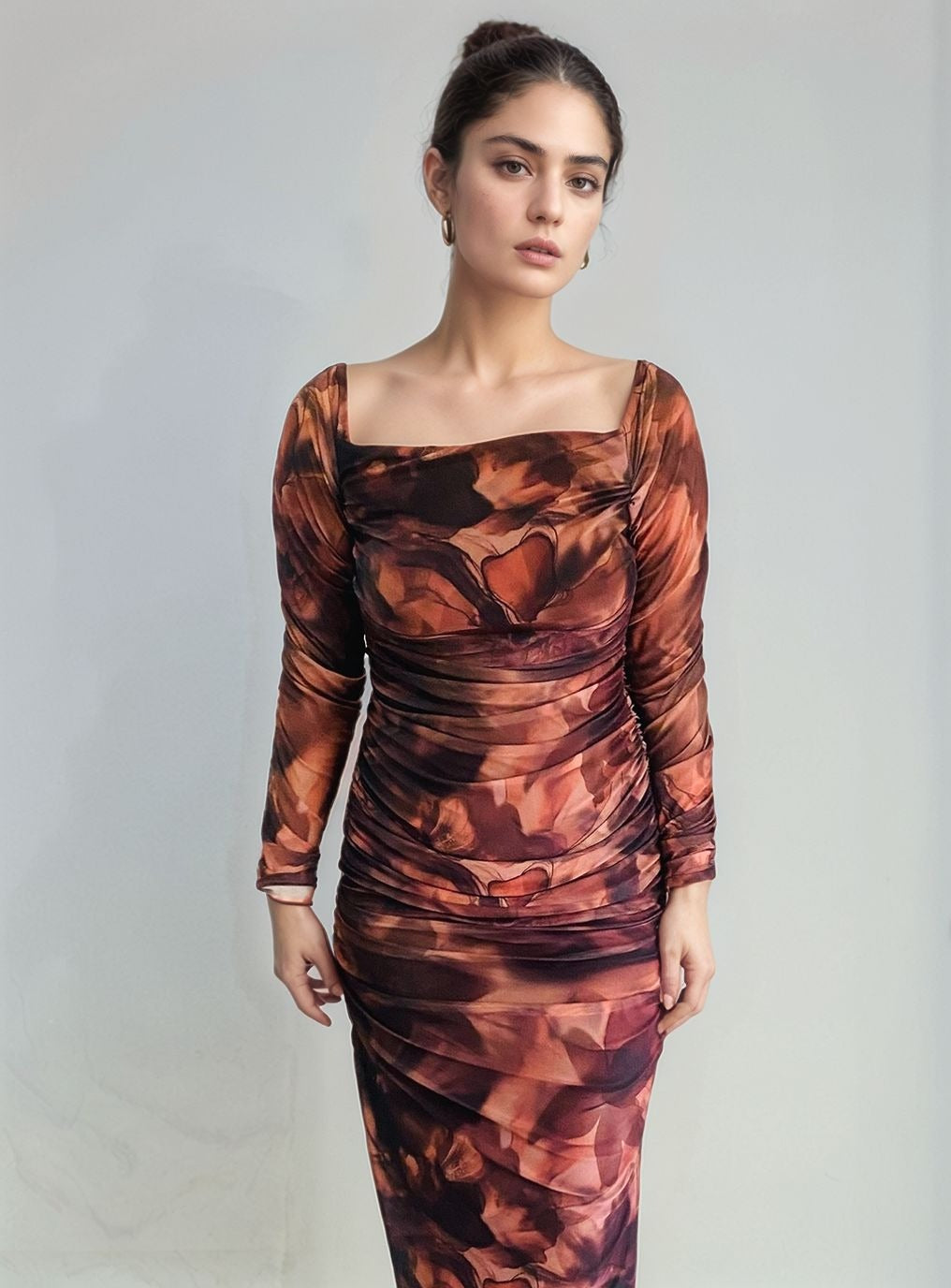 Front view of woman wearing off-shoulder FLORAL print bodycon maxi dress in cream and brown tones, hugging curves elegantly.