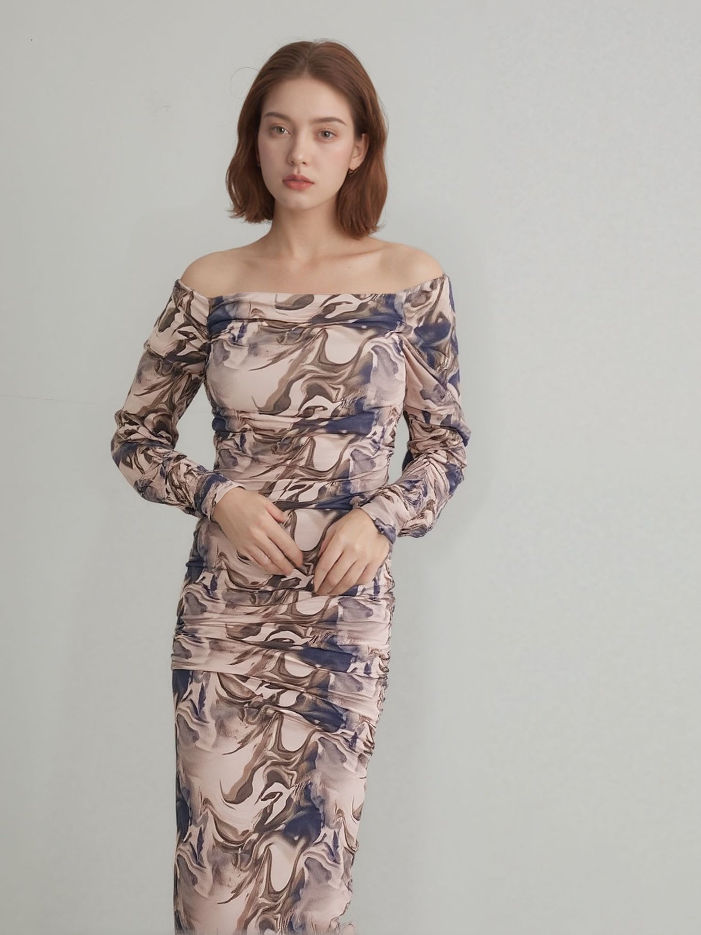  Woman wearing off-shoulder marble print bodycon maxi dress in cream and brown tones.