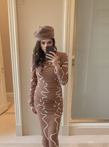 Mirror selfie of woman wearing swirl print ruched bodycon dress, styled with a brown beret.