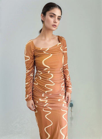 Close-up of model in ruched bodycon dress featuring white swirl pattern and off-shoulder neckline.
