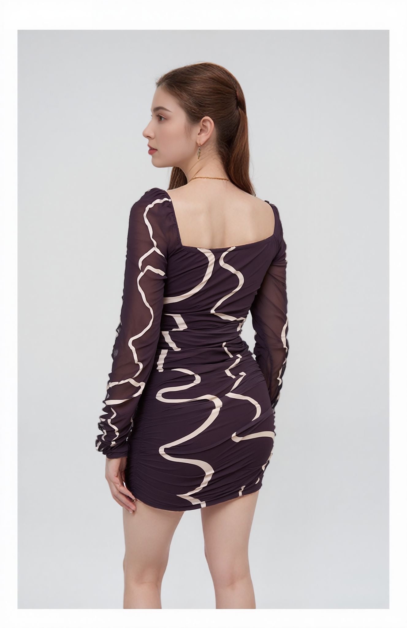 Woman wearing a dark BROWN dress with a wavy pattern on a white background