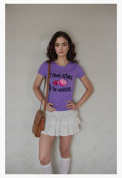 Woman wearing lavender graphic t-shirt with weekend slogan, styled with white skirt