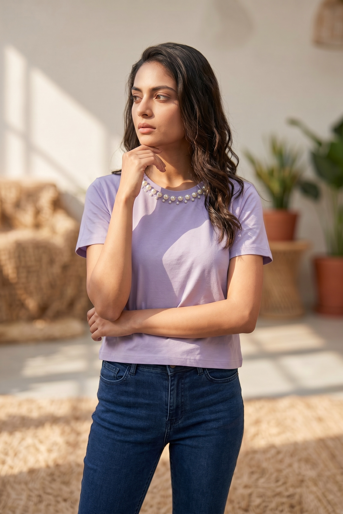 Model wearing a lavender pearl embellished crop top paired with blue jeans.
