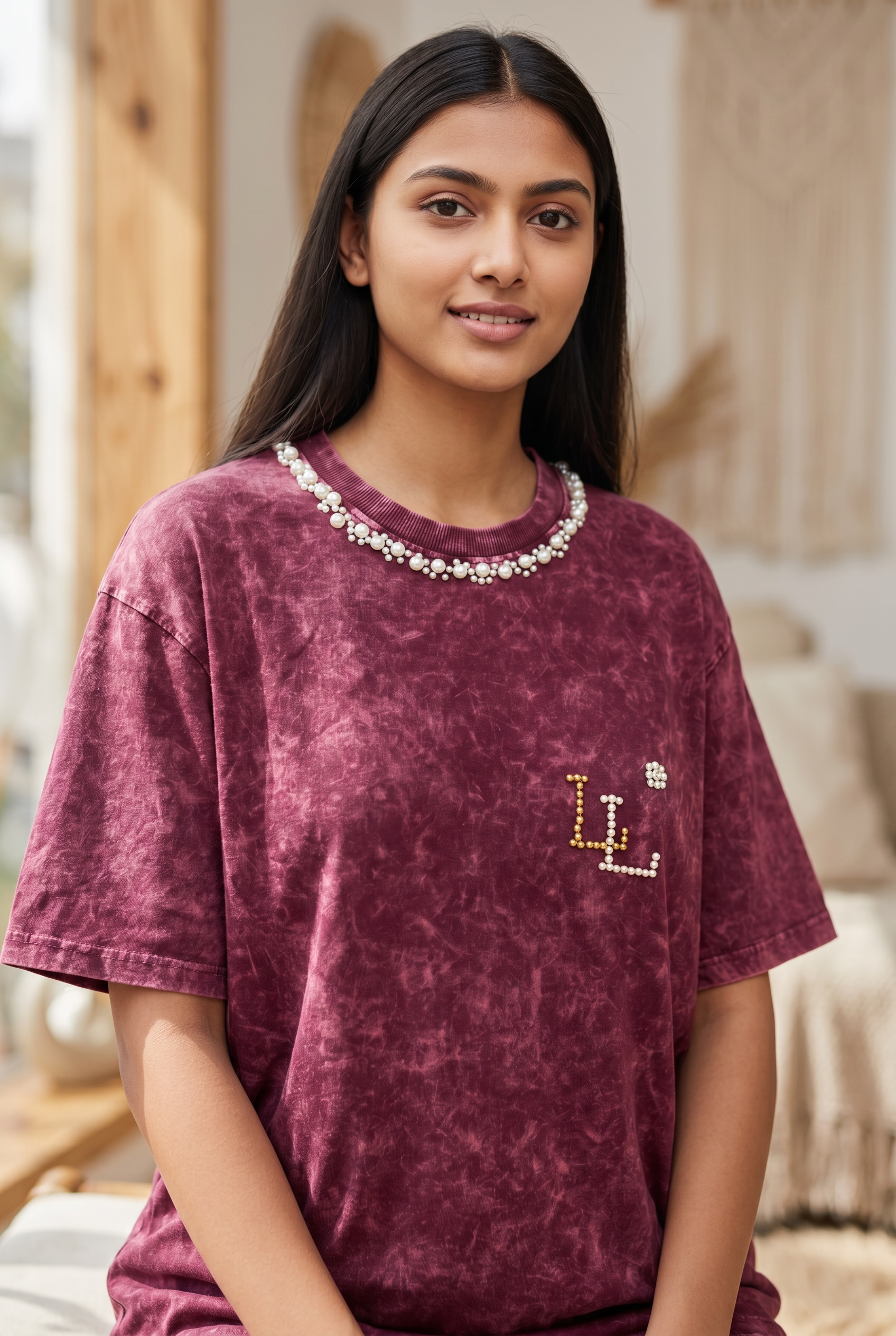 Front portrait of women’s maroon oversized acid wash T-shirt with pearl embellishments.
